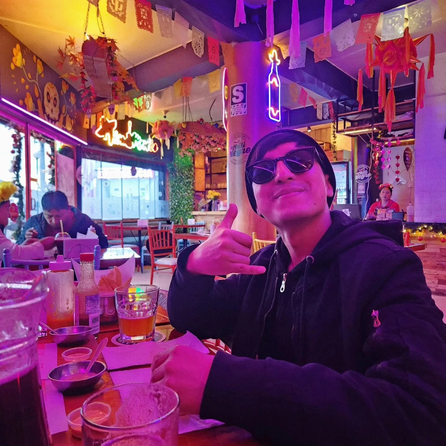 Cliente feliz en su mesa bajo las luces de neón